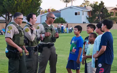 L.A. County Sheriff officers and kids talking in park